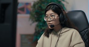 Amateur girl learns to play games on computer, talks through headset with team members, smiles, sudden turn of events woman loses round, disqualification, covers face with hands she is angry sad