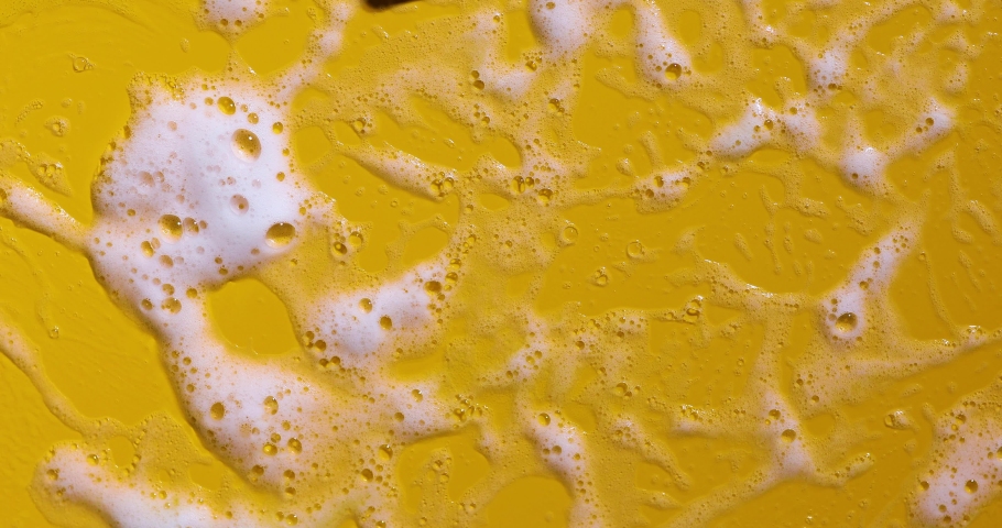 Texture of white soap foam with bubbles abstract yellow background, Soap, shower gel, shampoo, Face Cream cleansing mousse sample.