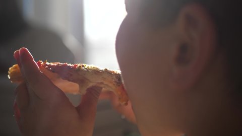 Kid eating a slice of pizza