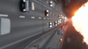 Moving cars on the motorway during sunset. Busy traffic on a freeway or highway, top view of the road. Scenic shot of trucks and cars. Defocused, blurry bokeh video. vertical video.