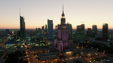 Warsaw, Poland - SEPTEMBER 2, 2021: Establishing Aerial Night view of Warszawa Business District Skyline. Palace of Culture and Science and Office buildings as Urban Cityscape. Drone zoom in shot