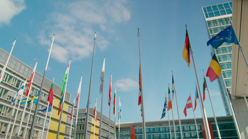 Waving Flags of European Union Countries in Court of European Parliament administrative office in Luxembourg City, Capital of EU. Politics, Economy and Global Business background. 4K panoramic shot - Powered by Shutterstock - Get 15% off with code: PIKWIZARD15