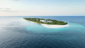 Tropical atoll island in Maldives with white sand beach and turquoise sea water. Touristic vacation holidays travel destination. Scenic landscape. Drone aerial video footage.