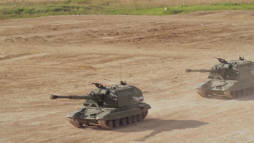 Two heavy Russian tanks are moving at high speed along the roads of the polygon.