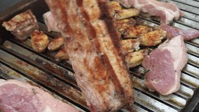closeup of a pork rib putting on the grill and throwing sea salt cooking in the day in 4k
