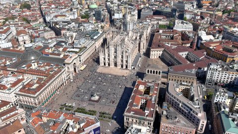 APRIL 7, 2022, Milan, Italy : The Milan Cathedral is the church of Milan, Lombardy, Italy. Flying by the famous Italian landmark ft panoramic aerial view of Piazza Duomo city square, Milano streets 6K