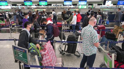 Hong Kong , Lantau Island , China - 02 20 2022: Passengers wait in line for a check-in counter airline at the Chek Lap Kok International Airport in Hong Kong, China.