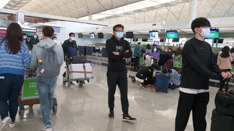 Hong Kong , Lantau Island , China - 02 20 2022: Passengers walk to a check-in counter airline at the Chek Lap Kok International Airport in Hong Kong, China.