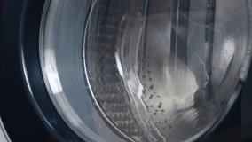 Washing machine washes dirty medical masks. Close up video of spinning drum washing machine