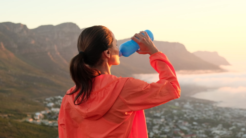 Young cauciasian fitness woman wearing sport clothes training outdoors drinking fresh water. Female in the morning after a run drinks water, restores water balance. weight loss hiking in the mountains | Shutterstock HD Video #1089158915