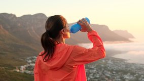 Young cauciasian fitness woman wearing sport clothes training outdoors drinking fresh water. Female in the morning after a run drinks water, restores water balance. weight loss hiking in the mountains - Powered by Shutterstock - Get 15% off with code: PIKWIZARD15