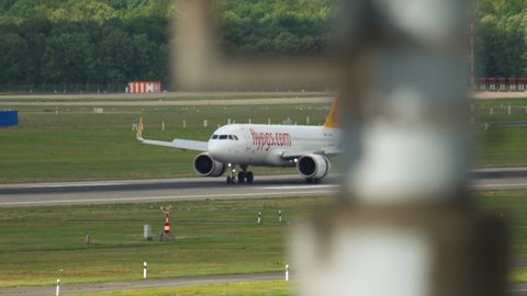 DUSSELDORF, GERMANY - JULY 23, 2017: Airbus A320 of Pegasus braking after landing at Dusseldorf airport (DUS). Footage plane rides on the airfield, runway
