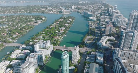 Aerial panoramic footage of urban neighbourhoods surrounded by water from both sides. Modern tall buildings on sea coast. Miami, USA