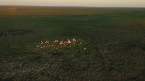 Yurts in tundra. Tipi, wigwam. Peoples of Far North. Sunset. Aerial view. Settlement in steppe.