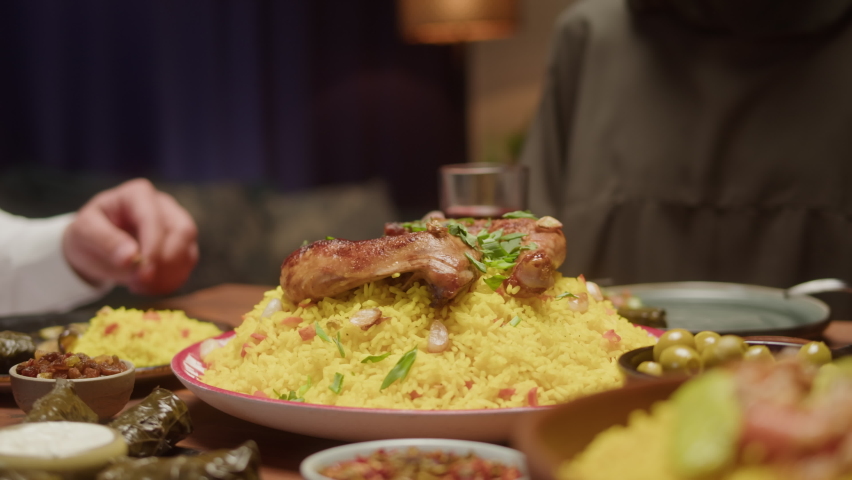 Muslim family dinner, eating togeher, Arabian cuisine. Ramadan, religious holiday, holy month. Couscous with eggplant, delicious rice and meat on table. Traditional middle eastern culture, worship.  Royalty-Free Stock Footage #1089168277