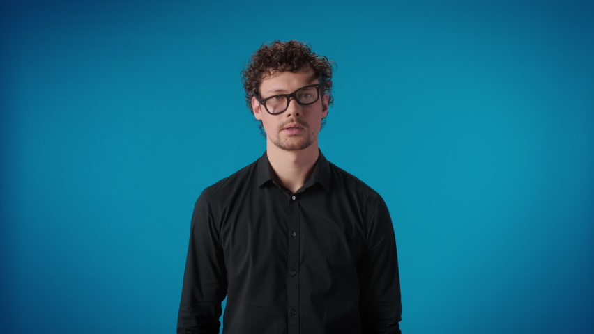 Portrait frustrated modern man shocked wearing skewed eyeglasses innovation science exploration posing isolated on blue studio overwhelmed male amazement astonishment face expression | Shutterstock HD Video #1089176525
