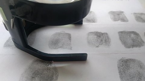 Fingerprints with a lens on a sheet of paper close-up