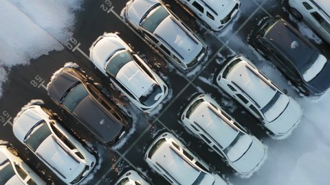 Aerial top down view of the car park of a car dealership or customs terminal with rows of new SUVs (crossovers)