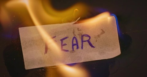 Closeup video of burning paper with FEAR written on it