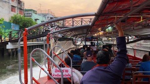 Bangkok, Thailand - April 8, 2022: Commuters ride the traditional Khlong boat, a type of water bus line, in Saen Saep canal.