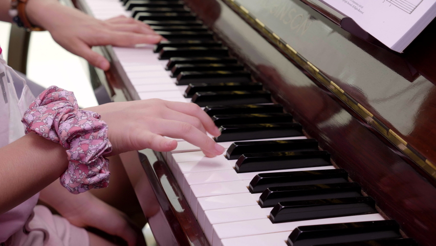 Close up of student hand piano with elder teacher teaching and helping to play Royalty-Free Stock Footage #1089184977