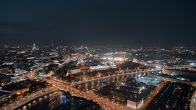 Beautiful aerial panorama of Moscow Kremlin at night. View from above to the towers of Kremlin, Moskva River and Kremlevskaya Naberezhnaya with evening lights and busy traffic in motion timelapse.