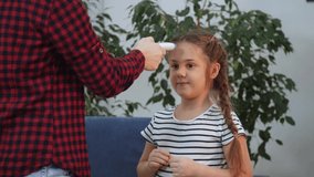 mom measures the temperature with an infrared thermometer, the little girl fell ill coronavirus. lockdown stay home social distance coronavirus covid 19. temperature measurement during coronavirus - Powered by Shutterstock - Get 15% off with code: PIKWIZARD15