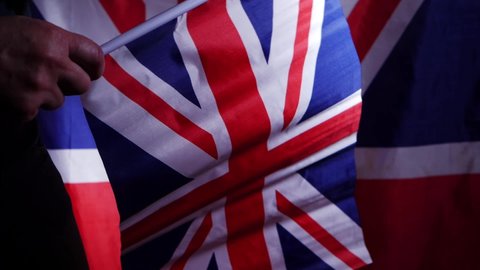 British citizen waving Union Jack flag medium shot sow motion selective focus