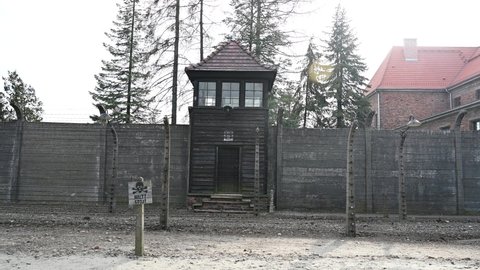Auschwitz, Poland, March 2022:  Watchtower and barbered wire in Auschwitz concentration camp. Auschwitz concentration and extermination camp.  Nazi death camp. Watchtower and fence system.