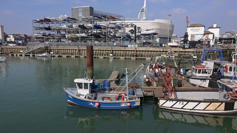 Portsmouth, Hampshire, UK, March 25 2022. Footage of the small fishing boats in Camber Quay in Portsmouth Harbour with the Bridge Tavern and Portsmouth Point in the background.