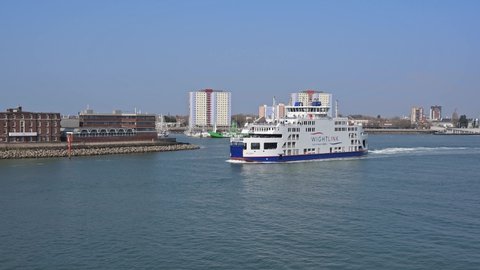 Portsmouth, Hampshire, UK, March 25, 2022. Wightlink ferry St Clare arrives into Portsmouth Harbour with Gosport in the background.