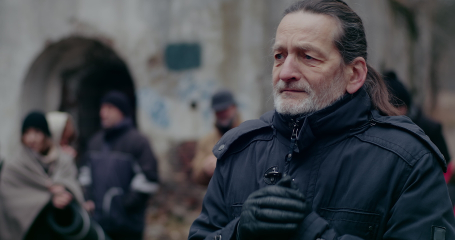 Senior Male Refugee Suffering In Cold During War.