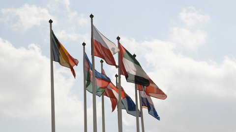 Various national flags with the EU flag under a blue sky.