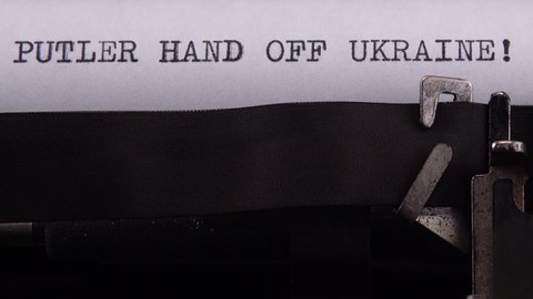 Kyiv, UKRAINE - APRIL 02, 2022: 
Typing phrase "PUTLER HAND OFF UKRAINE !" on retro typewriter.