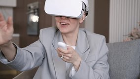 Beautiful woman wearing virtual reality headset. Augmented Reality. Happy cute business woman touch something using modern 3D glasses indoors. Woman playing using VR goggles at home. New technologies