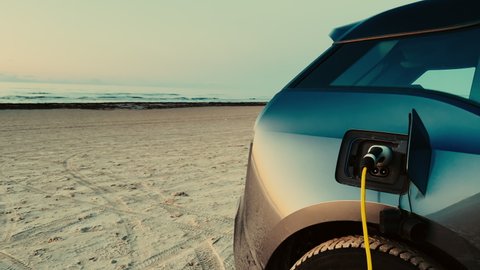 Electric car is charged at E-vehicle charging station on BEACH