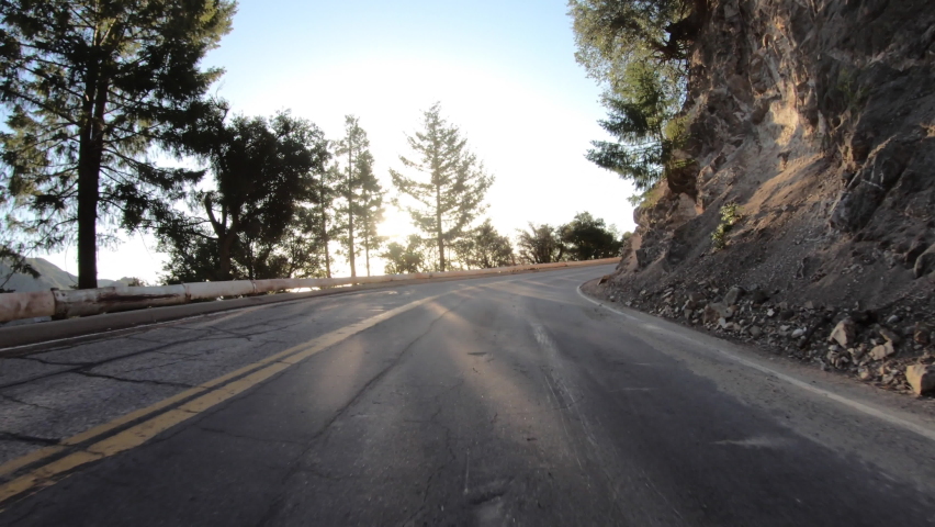 Early morning sunlight shinning through trees on Mt Wilson Road in the San Gabriel Mountains above Los Angeles County, California.