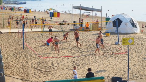 Samara, Russia - circa March, 2022: A group of people playing beach volleyball on the sand