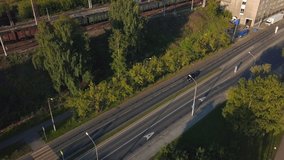 Top view of car driving along suburban highway on summer day. Clip. Beautiful suburban highway with single car on sunny morning