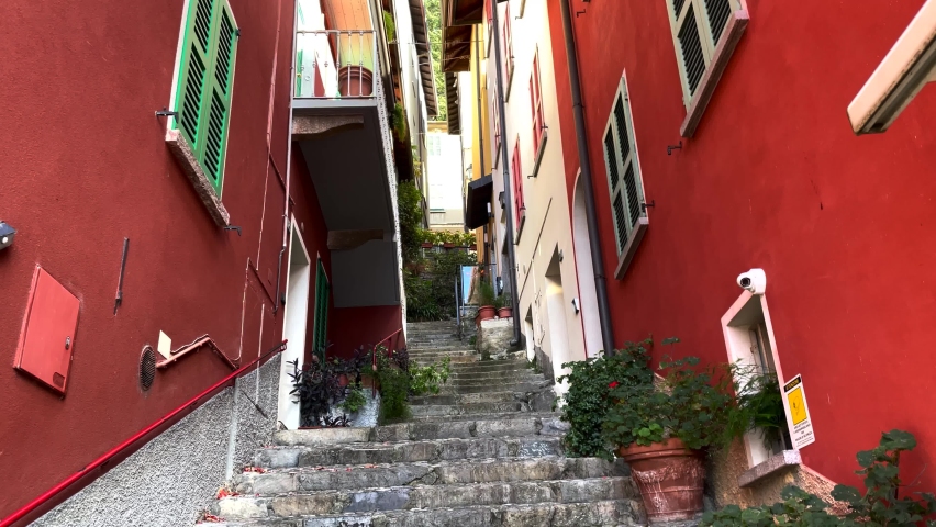 View to the narrow street in italian town with stairs and flower pots on side.