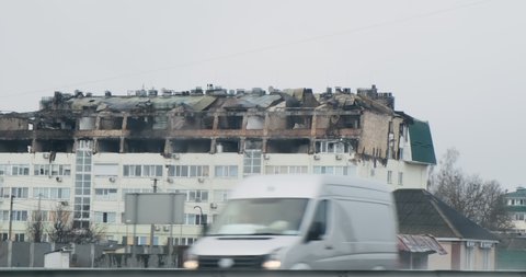 Ukraine, Kyiv, 2022. Ukraine war. Destroyed, burnt, bombed houses along road. View from driving car. Evacuation from war zone. Bomb attacks in Kyiv region. Rocket destroying city residential building