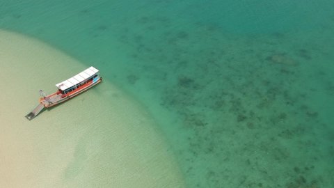 Drone shot flying top view over the blue sea and white sand witn long tail boat at Fabric island in Phang Nga bay Thailand