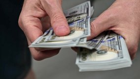 close-up of male hands counting a stack of hundred-dollar US banknotes. a businessman is counting cash. the concept of investment, money exchange, bribes or corruption. selective focus. - Powered by Shutterstock - Get 15% off with code: PIKWIZARD15