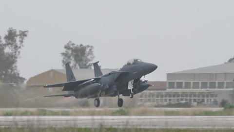 Andravida Greece APRIL, 1, 2022 Heavy strike bomber jet plane of USAF take off in grey bad weather sky. Boeing F-15E Strike Eagle all-weather multirole strike fighter jet of United States Air Force