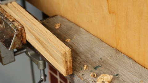 carpenter works with a planer, shavings close-up
