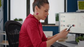 Financial analyst using smartphone to browse internet website, working in startup company office. Employee looking at mobile phone screen and doing economic data research, online analysis. - Powered by Shutterstock - Get 15% off with code: PIKWIZARD15