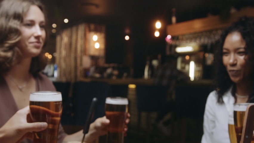 Multi-ethnic group of friends clinking glasses of beer at a restaurant. Royalty-Free Stock Footage #1089230137