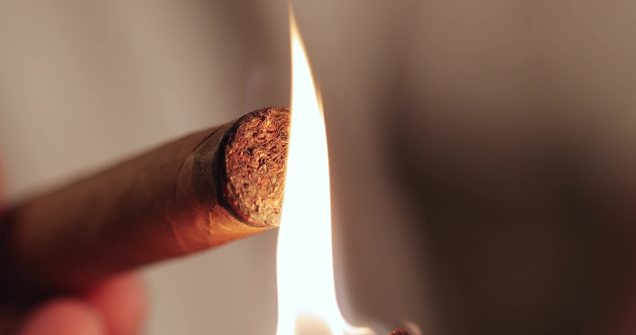 A match is burning and setting fire to a Cuban cigar. man's hands light a cigarette. macro | Shutterstock HD Video #1089230995