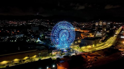 Blue ferris wheel at town of Rio de Janeiro Brazil. Amusement park landscape. Darkness scenery at dowtown district. Night landscape of cityscape of blue ferris wheel at town of Rio de Janeiro Brazil.