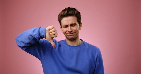 Unhappy man giving thumbs down gesture